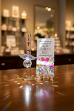 New Acrylic Crystal guardian angel sun catcher and car charm, featuring a colourful beaded strand, floral-patterned acrylic wings, and a faceted crystal prism, dark pink hanger