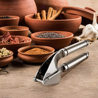 New Stainless Steel Kitchen Garlic Press! Comes with a Garlic Peeler Rocker giving you the option just to peel your garlic without peeling with your hands.